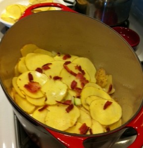 Layering the potatoes, cheese, onion, and bacon