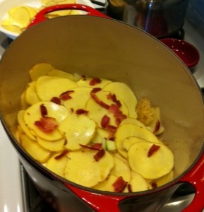 Layering the potatoes, cheese, onion, and bacon